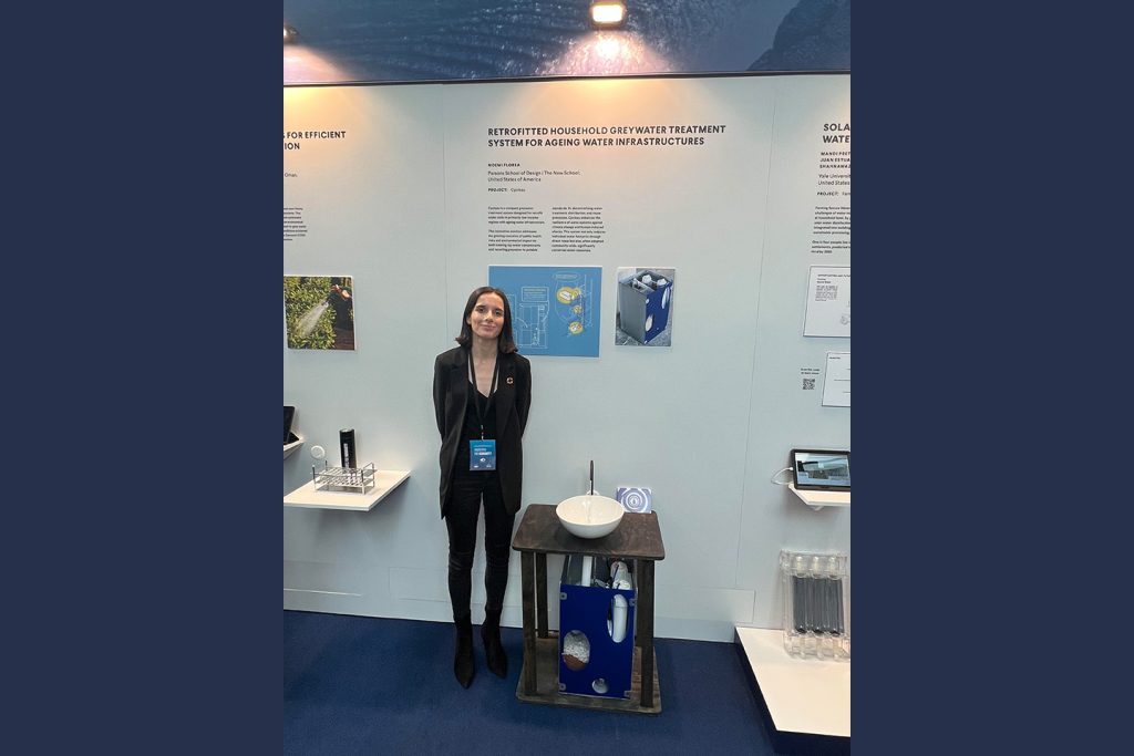 Noemi Florea stands in her conference exhibit, next to a protype of her greywater treatment system.