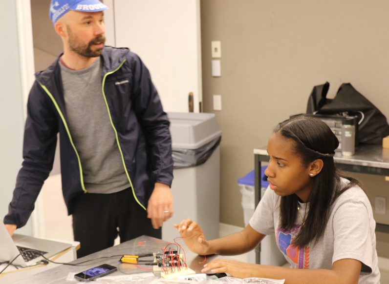 Ryan Raffa, a a part-time lecturer at Parsons who leads the Creative Technology Course, instructs student Noelia Baptista on the design process.