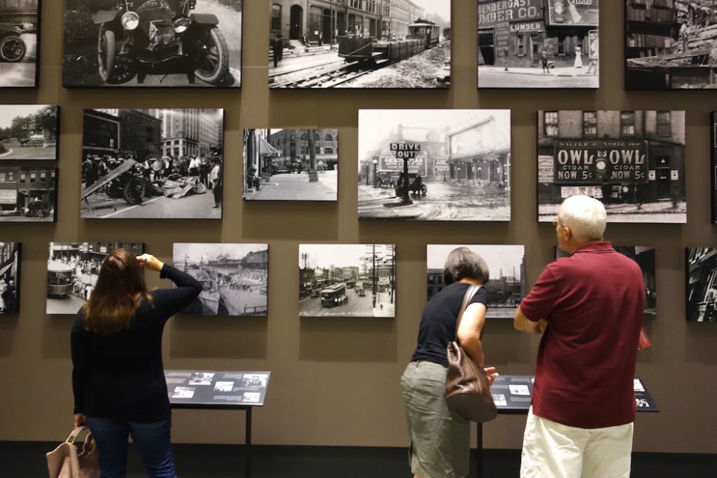 Patrons at the Missouri History Museum in St. Louis examine photographs in the Capturing the City exhibit, which runs from August 2016 through January 2017.