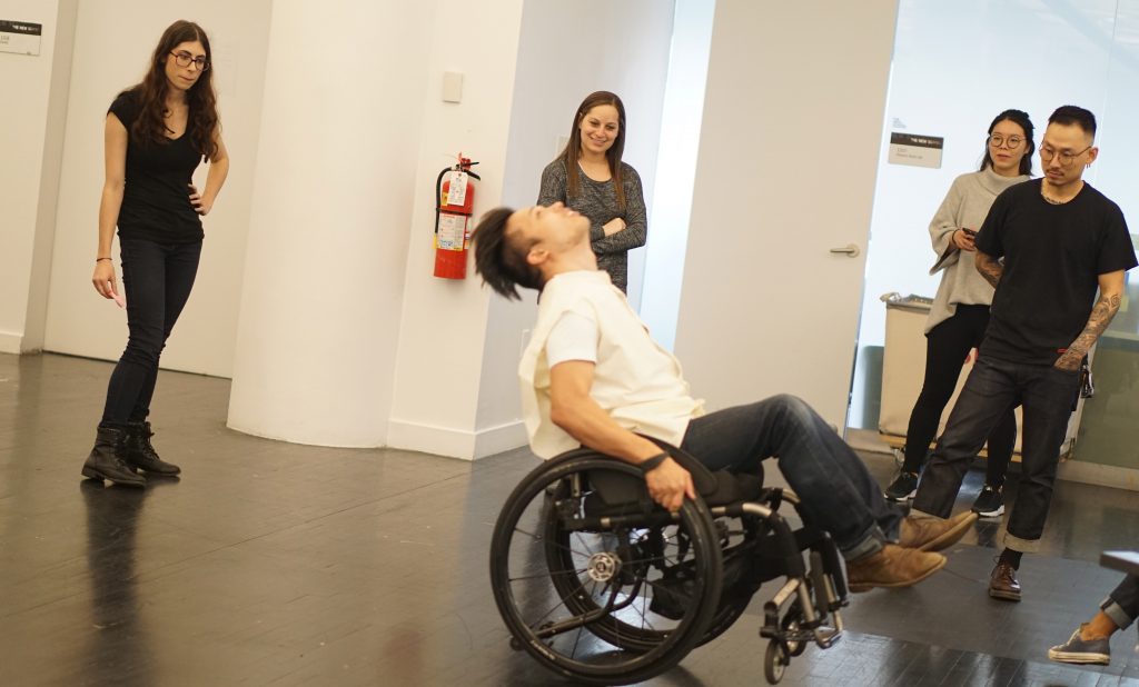 The OSL team of, from L-R, Angela Delise, Elizabeth Bodzy, Chuyi Sun, and Jonathan Lee watch as their client, Peter Trojic, moves around in his wheelchair.