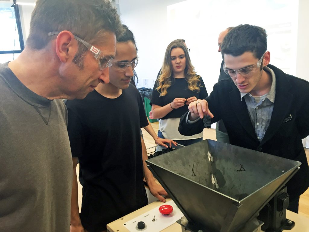 Max Ginesin and Giovanna Vista, BFA Product Design '18, and Max Kitchell, BFA Product Design '17, demonstrate how to use the shredder they designed and built in Dave Marin's Build Your Own Factory class (Photo/Scott Gargan)